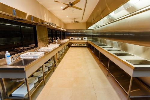 a large kitchen with a long row of counters at Global Backpackers Cairns in Cairns