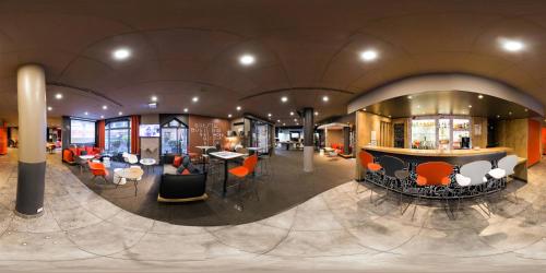 a large room with a bar and tables and chairs at ibis Toulouse Centre in Toulouse