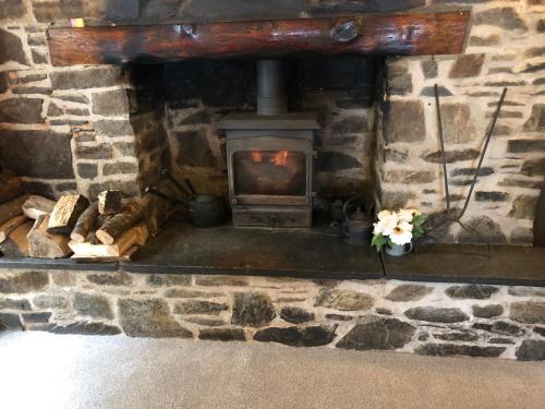 a stone fireplace with a wood stove in it at The Royal Oak Inn in Withypool