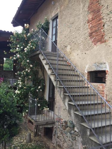 schody prowadzące do budynku z kwitnącym drzewem w obiekcie Appartamenti a Magnano w mieście Magnano