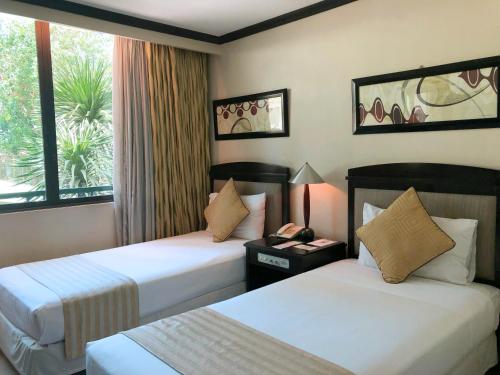 Säng eller sängar i ett rum på Tower Inn Makati Business Hotel