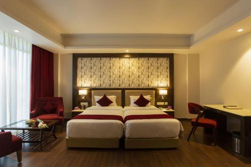 a hotel room with a bed and a desk at Sarovar Portico, Somnath in Somnath