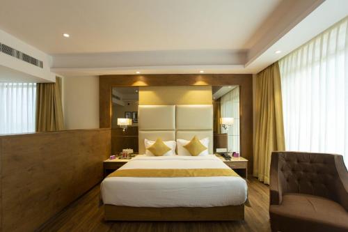 a hotel room with a bed and a couch at Sarovar Portico, Somnath in Somnath