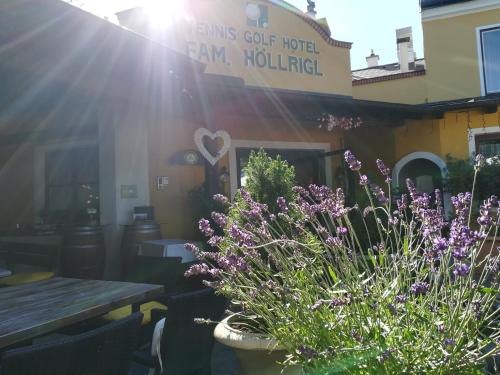 a garden with purple flowers in front of a restaurant at Tennis Golf Hotel Höllrigl in Kottingbrunn