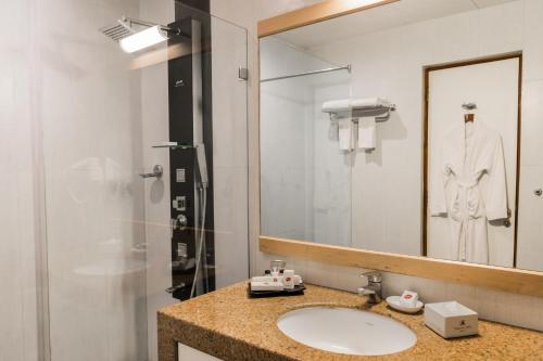 a bathroom with a sink and a mirror at Chances Resort and Casino An Indy Resort in Panaji