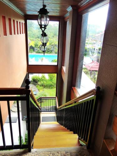 a staircase in a house with a window and a chandelier at Toraja Torsina Hotel in Rantepao