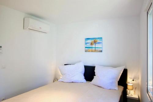 a bed with white pillows in a room with a window at Els Poblets WD by CARLOSFERIEN in Els Poblets