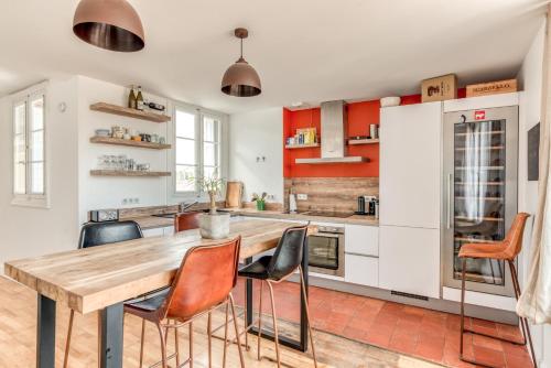 une cuisine avec une table et des chaises en bois dans l'établissement Les Clés de Laure - Wine Loft, Terrasse et Vue extraordinaire sur la cité médiévale, à Carcassonne