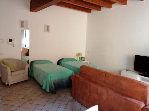 sala de estar con 2 camas y sofá en Soggiorno in Centro Storico, en Vimercate