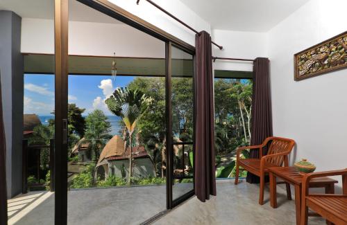 a room with a large window with a view of the ocean at The Cove Phi Phi in Phi Phi Don