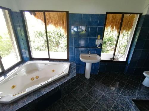 baño con bañera grande y lavamanos en The Blue Orchid Resort, en Moalboal