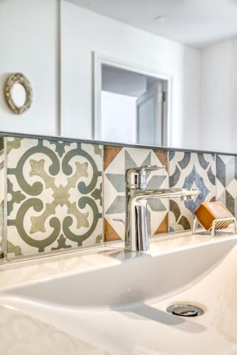 un lavabo de salle de bain avec un robinet et un miroir dans l'établissement Les Clés de Laure - Wine Loft, Terrasse et Vue extraordinaire sur la cité médiévale, à Carcassonne