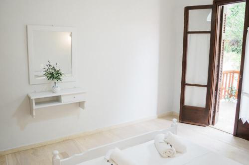a white room with a mirror and a sink at Afroditi Pansion in Agios Nikitas