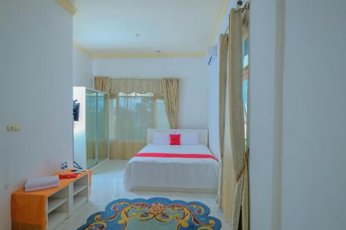 a bedroom with a bed and a mirror in it at RedDoorz Syariah near Museum Lambung Mangkurat 2 in Banjarbaru
