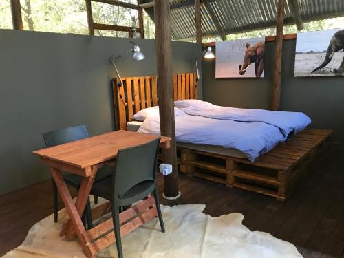 Phazama Farm في ماون: غرفة نوم بسرير ومكتب وطاولة