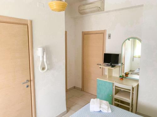 a room with a bathroom with a desk and a mirror at Hotel Zamagna in Cesenatico