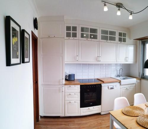 a white kitchen with white cabinets and a sink at Amplio apartamento a 5 minutos del centro in Lugo