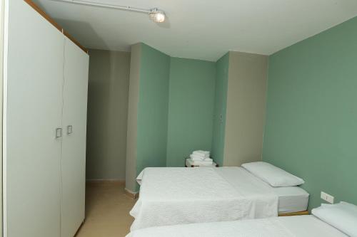 two beds in a room with green walls at Cimer SafraMarine Beach Resort in Safra