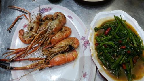 two plates of food with shrimp and vegetables on a table at Stash in Bangkok