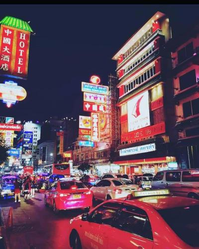 a busy city street with cars and signs at night at Stash in Bangkok