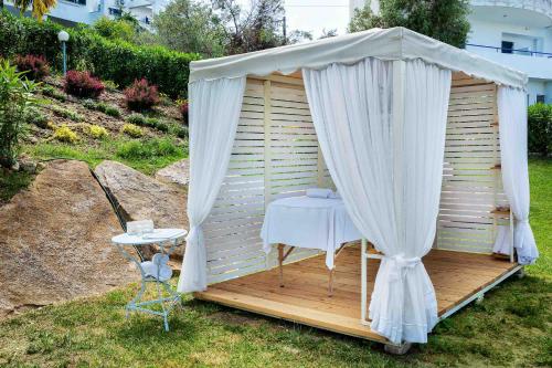 a gazebo with a table and a white canopy at Hotel Kriopigi in Kriopigi