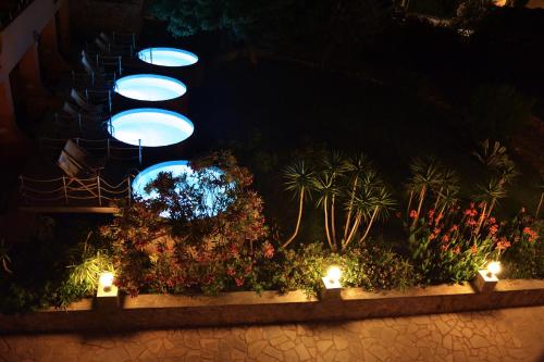 a group of lights in a garden at night at Orpheas Resort Hotel (Adults Only) in Georgioupolis