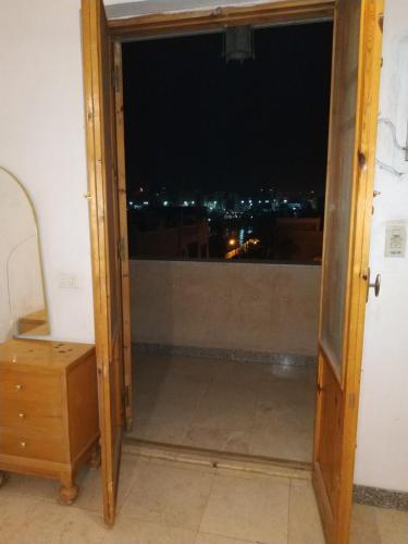 a door to a balcony with a view of a city at Adad Noubian House in Aswan
