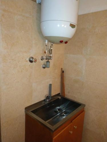a sink in a bathroom with a light on the wall at Adad Noubian House in Aswan