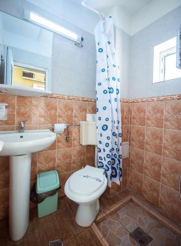 a bathroom with a toilet and a sink at COMPLEX Alutus -Camere de inchiriat in Mangalia