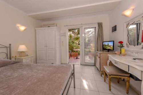 a bedroom with a bed and a bathroom with a sink at Orpheas Resort Hotel (Adults Only) in Georgioupolis