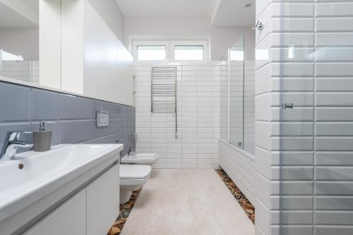 a white bathroom with a toilet and a sink at Riviera Zoloche Resort & Spa in Vishenki