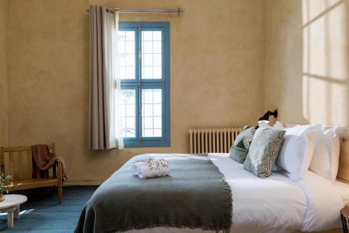 a bedroom with a large bed with a window at La Maison des Sources in ‘Ayn Zḩaltā