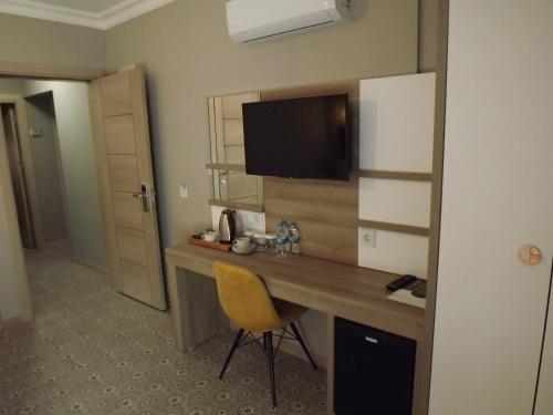 a hotel room with a desk with a television on the wall at ACR PALAS in Edirne