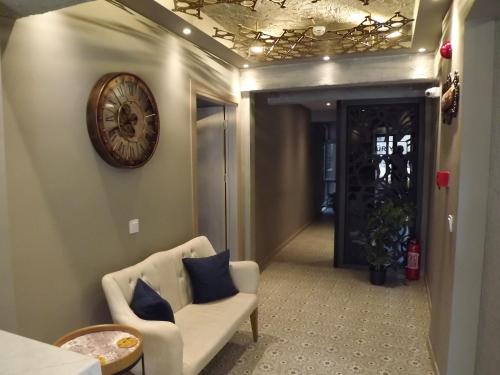 a hallway with a couch and a clock on the wall at ACR PALAS in Edirne