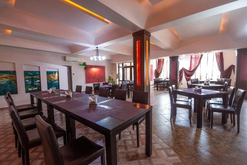 a restaurant with tables and chairs in a room at COMPLEX Alutus -Camere de inchiriat in Mangalia
