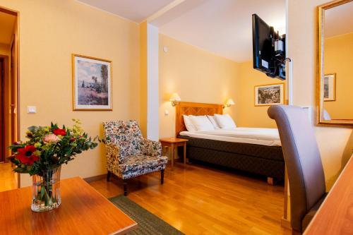 ヴェステロースにあるSure Hotel by Best Western Esplanadeのベッド、椅子、テーブルが備わるホテルルームです。