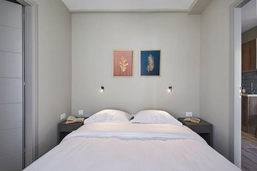 una camera da letto con un grande letto bianco con due tavoli di Spacious Suite w. huge balcony + Acropolis view ad Atene