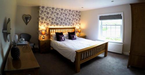 a bedroom with a large bed and a window at The Vine B & B in South Thoresby