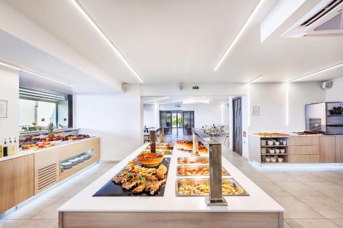a large kitchen with many trays of food at Hotel Kriopigi in Kriopigi