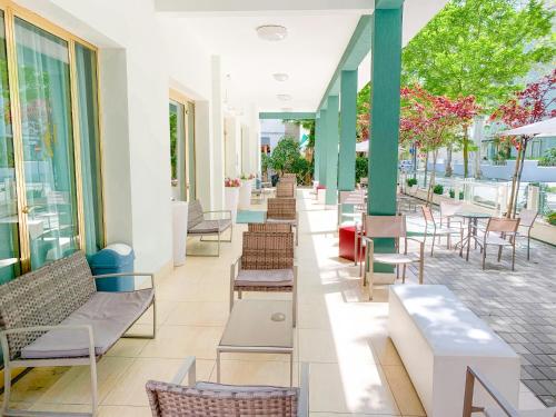 a building with chairs and tables and windows at Hotel Zamagna in Cesenatico