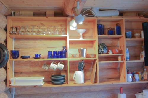 a wooden shelf with glasses and dishes on it at Purje Holiday Home in Heltermaa
