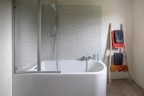 een badkamer met een bad en een douche bij Vakantiehuis Hana in Heers