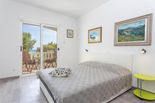 a bedroom with a bed and a balcony at Apartments Gilve in Hvar