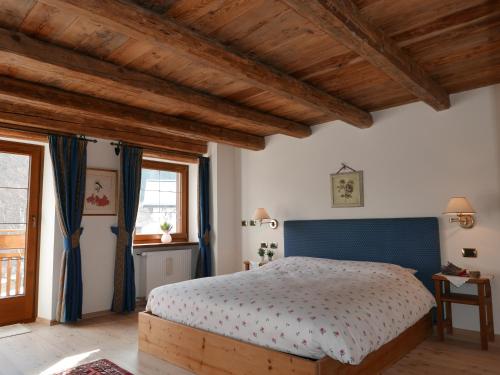 Schlafzimmer mit einem Bett und Holzdecken in der Unterkunft Rocca B&B in Rocca Pietore