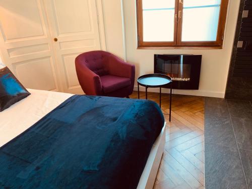 ルーアンにあるLa suite Marilynのベッドルーム(ベッド1台、椅子、暖炉付)