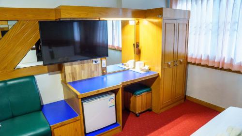 a small room with a desk and a television at โรงแรมศิริโฮเต็ล Sirihotel Korat in Nakhon Ratchasima