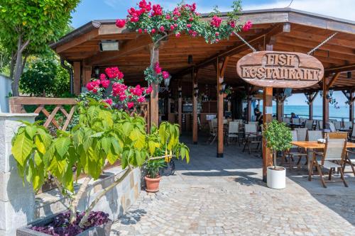 a restaurant with flowers and tables and chairs at Garden of Eden Complex in Sveti Vlas
