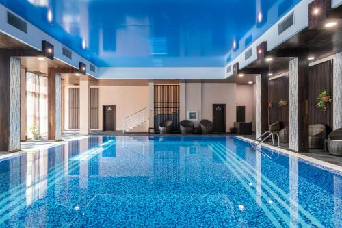 a large pool with blue water in a building at Garden of Eden Complex in Sveti Vlas