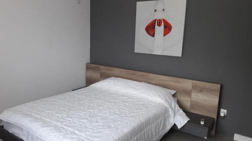 a bedroom with a white bed and a picture on the wall at villazur in Flic-en-Flac