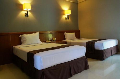 Een bed of bedden in een kamer bij HOTEL ASRI CIREBON